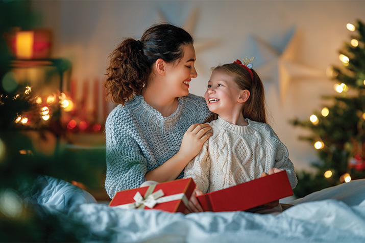 Mom and girl with presents enjoying 'Twas the night before Christmas activities